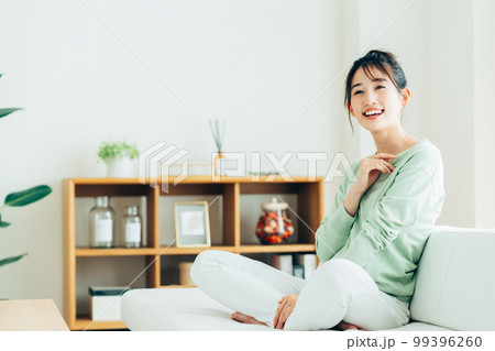 リビングでくつろぐ若い女性 99396260