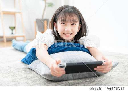 寝転んでゲームをする女の子 寝転んでゲームをする女の子 99396311