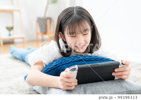 寝転んでゲームをする女の子 寝転んでゲームをする女の子 99396313