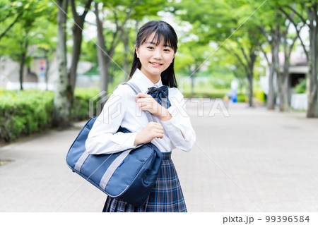通学する夏服の学生服を着た女子中学生 99396584