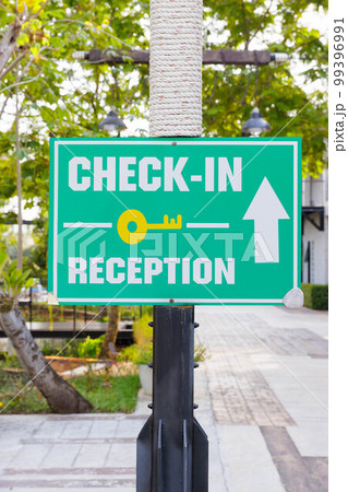 Outdoor green sign show the direction to check in at the reception in a resort Outdoor green sign show the direction to check in at the reception in a resort 99396991