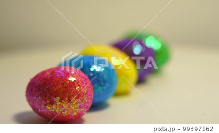 Colorful Easter eggs rotating in rows in a seamless loop on a light background Colorful Easter eggs rotating in rows in a seamless loop on a light background 99397162