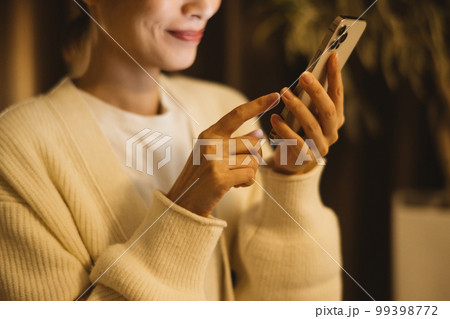夜にスマホを見る女性 99398772