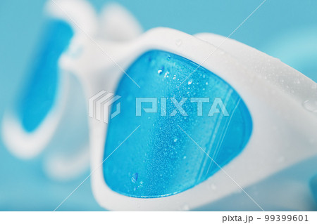 White swimming goggles on a blue background White swimming goggles on a blue background 99399601