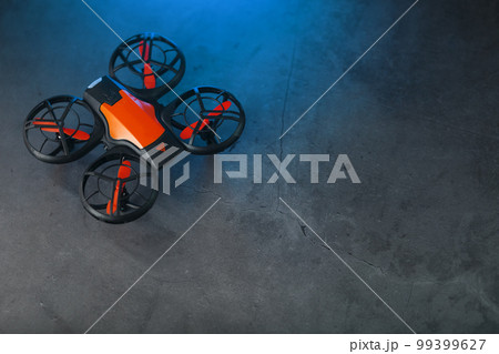 A reconnaissance quadcopter drone with an orange body a A reconnaissance quadcopter drone with an orange body a 99399627