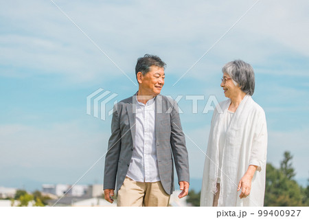 街を話しながら歩く日本人の高齢者夫婦（シニア・男女） 99400927