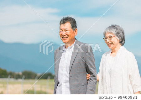 街を話しながら歩く日本人の高齢者夫婦（シニア・男女） 99400931