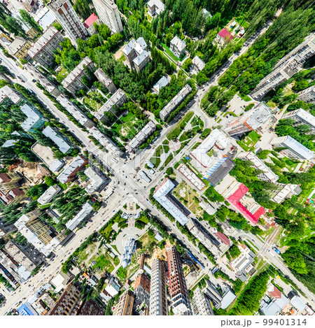 Aerial city view with crossroads and roads, houses, buildings, parks and parking lots. Sunny summer panoramic image 99401314