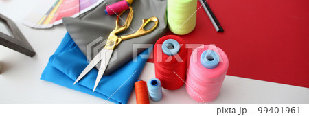 Multicolored fabric threads and scissors in atelier at workplace 99401961