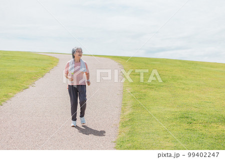 公園でウォーキング・有酸素運動・ランニングする高齢者女性 99402247