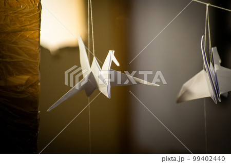 Japanese folded Origami cranes hanging on with strings. Hundreds handmade paper birds isolated with copy space. 1000 thousand crane sculpture topic. Symbol of peace, faith, health, wishes, hope Japanese folded Origami cranes hanging on with strings. Hundreds handmade paper birds isolated with copy space. 1000 thousand crane sculpture topic. Symbol of peace, faith, health, wishes, hope 99402440