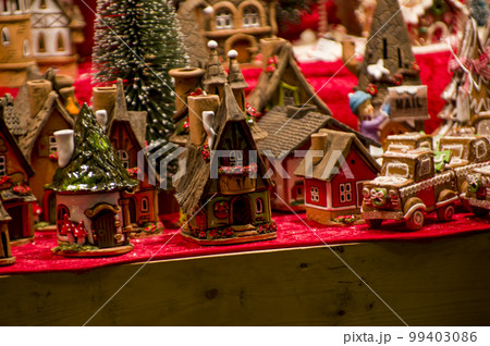 Advent Bazaar Stalls with glass, wooden, ceramic christmas souvenirs in shops. Close up of festive decorations for tree in winter street night market during new year's holiday. Illuminated fair kiosk Advent Bazaar Stalls with glass, wooden, ceramic christmas souvenirs in shops. Close up of festive decorations for tree in winter street night market during new year's holiday. Illuminated fair kiosk 99403086