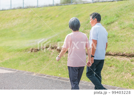 公園でウォーキング・有酸素運動する高齢者夫婦の後ろ姿（シニア・男女） 99403228