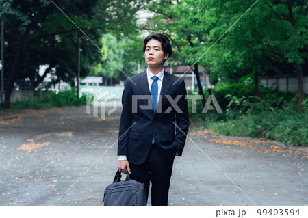 緑道を歩くスーツ姿のビジネスマン 緑道を歩くスーツ姿のビジネスマン 99403594