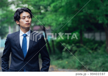 緑道を歩くスーツ姿のビジネスマン 99403597