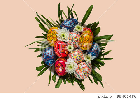 Easter eggs and spring flower on green grass on the plate on isolated background top view Easter eggs and spring flower on green grass on the plate on isolated background top view 99405486