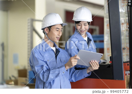 打ち合わせをする倉庫内作業員 打ち合わせをする倉庫内作業員 99405772