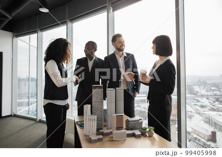 Team of diverse four multiethnic businesspeople shaking hands with each other Team of diverse four multiethnic businesspeople shaking hands with each other 99405998