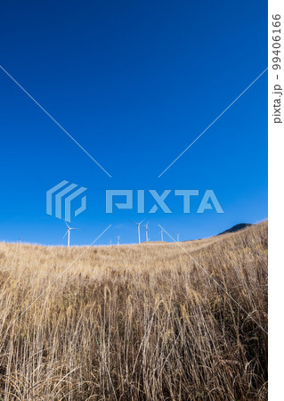 白い雲と青空の阿蘇に吹く風に風力発電が回る風景 99406166