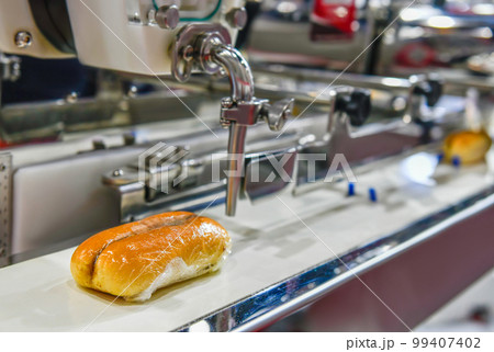 Automatic hamburger buns production line on conveyor belt equipment machinery in factory, industrial food production. Automatic hamburger buns production line on conveyor belt equipment machinery in factory, industrial food production. 99407402