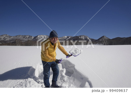 雪国で除雪をする笑顔の日本人シニア 雪国で除雪をする笑顔の日本人シニア 99409637
