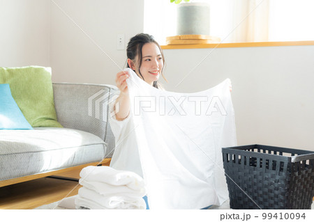 洗濯物を畳む女性 99410094