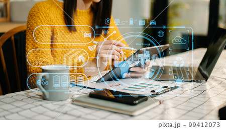Businesswoman working virtual tablet computer twith reduce CO2 concept with icons, global warming such as reforest green factory recycle in office 99412073