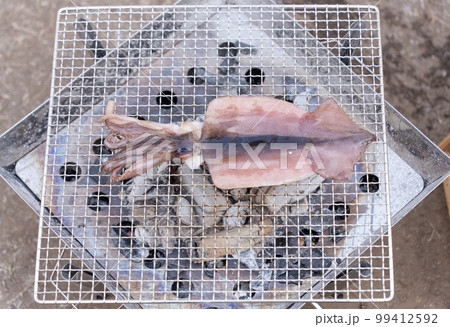 網焼きで北海道産のイカを焼いている 99412592