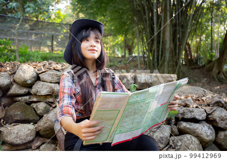 Asian teenager woman travel backpack looking map for direction of destination of journey. 99412969