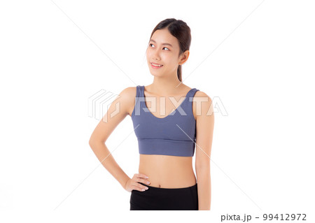Portrait of beautiful young asian woman in sportwear smile and showing waist and abs isolated. 99412972