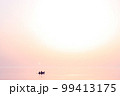 Sunset at sea. Romantic photo with the sea rolling in the sky and the couple in love in a boat. Pink sunset, big sun, bright lights, waves, black silhouette of people in a boat. Copy space 99413175