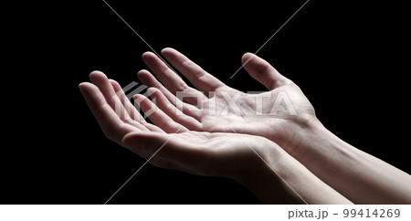 The outstretched hands of a praying man 99414269