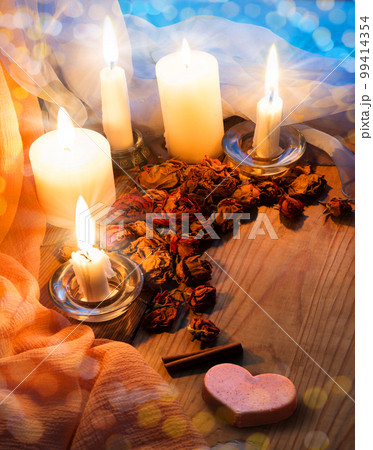 Candles and dried rosebuds on the table 99414354