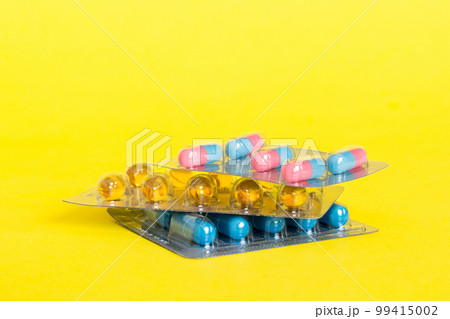 too many different pill cartridges stacked. selective Focus. Packs of blister pills with tablets. Colored pastilles packages. A pile of medicine in blister packs. Pharmaceutical blister packs 99415002