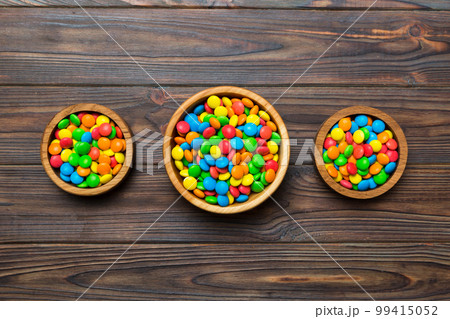 different colored round candy in bowl and jars. Top view of large variety sweets and candies with copy space 99415052
