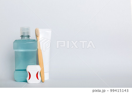 Mouthwash and other oral hygiene products on colored table top view with copy space. Flat lay. Dental hygiene. Oral care products and space for text on light background. concept 99415143