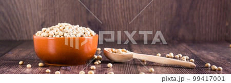 Raw soybean seeds in a bowl, spoon and jar on the table. Source of vegetable protein. Web banner 99417001