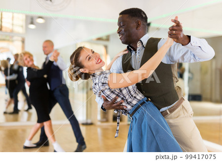 Woman with american man practising ballroom dancing 99417075