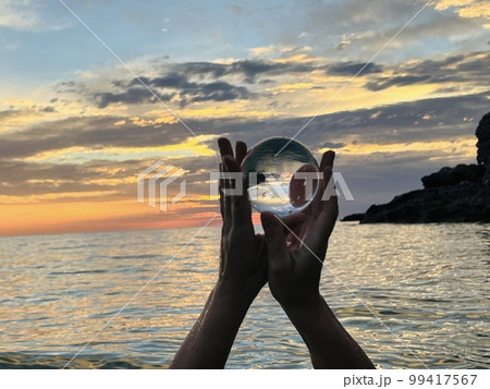 Beautiful scenic view through lens of crystal ball at summer sunset.  99417567