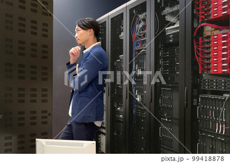 サーバールームでコンピューターをチェックする情報システム担当者　情シス　ビジネスイメージ 99418878