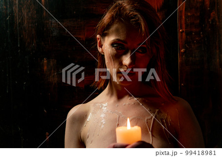 Body scape of a well-shaped woman with a burning candle and wax on her bum Body scape of a well-shaped woman with a burning candle and wax on her bum 99418981