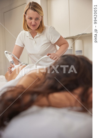 roller massage, Correction figures, microdermabrasion equipment. Attractive young woman is participating in beauty services, body shaping, vacuum roller massages. Offering clients figure correction 99420051