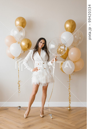 Young caucasian woman holding a balloon in her hands in honor of her thirtieth birthday Young caucasian woman holding a balloon in her hands in honor of her thirtieth birthday 99420334