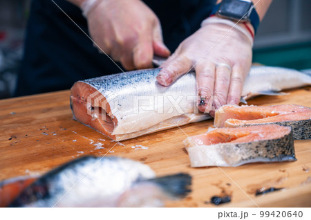 Chef preparing a salmon fish 99420640