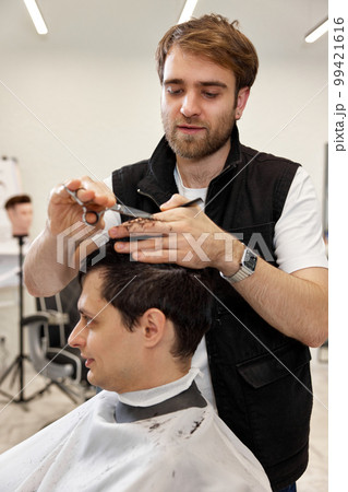 hairdresser does haircut for caucasian bearded man hairdresser does haircut for caucasian bearded man 99421616