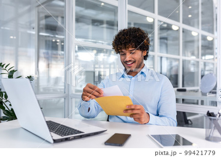 Young successful businessman inside office working with laptop, man received good news notification mail, hispanic man reading news and smiling at workplace, happy with achievement result. Young successful businessman inside office working with laptop, man received good news notification mail, hispanic man reading news and smiling at workplace, happy with achievement result. 99421779