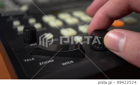 A man sets up remotely controlled cameras. Camera control panel. Hand close up. 99422524