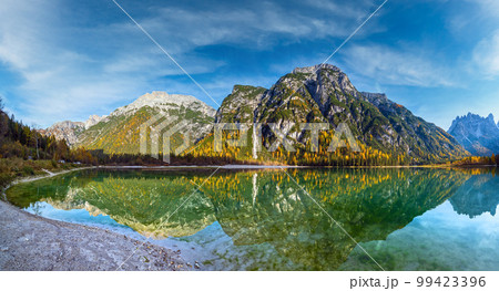 Autumn peaceful alpine lake Durrensee or Lago di Landro. Snow-capped Cristallo rocky mountain group behind, Dolomites, Italy, Europe. Seasonal and nature beauty concept. People and cars unrecognizable 99423396