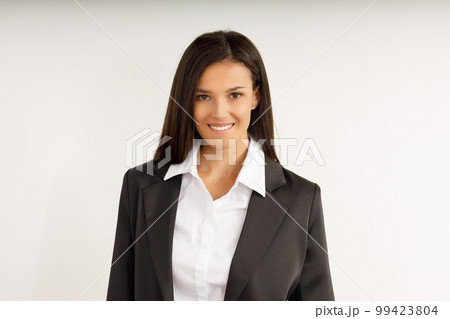 Portrait of happy smiling brunette businesswoman dressed in white shirt and black jacket. Beautiful model on isolated white background. Studio shot of young attractive woman in business suit. Portrait of happy smiling brunette businesswoman dressed in white shirt and black jacket. Beautiful model on isolated white background. Studio shot of young attractive woman in business suit. 99423804
