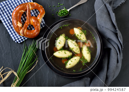 Bavarian, Swabian and Austrian dish - semolina dumplings  in a vegetable broth served with a pretzel 99424587